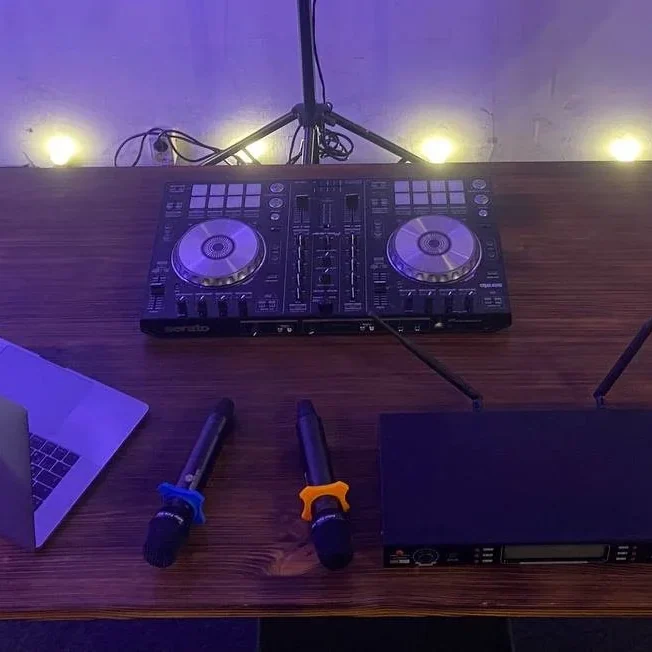 DJ-контроллер, ноутбук и радиомикрофоны на диджейском столе на мероприятии в Санкт-Петербурге